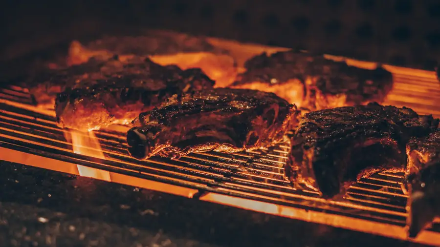 Cortes grossos na grelha da parrilla com brasa acesa
